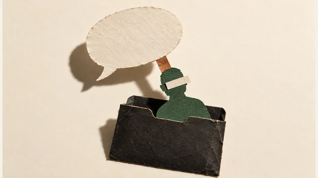 A blank paper speech bubble connects by a copper-colored tab to a green human silhouette emerging from a worn black folder. An ivory strip covers its eyes; hard shadows fall across the ivory background.